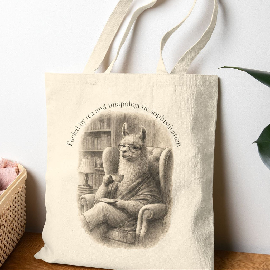 Tote bag with a cat illustration and text on a wooden surface with a plant in the background