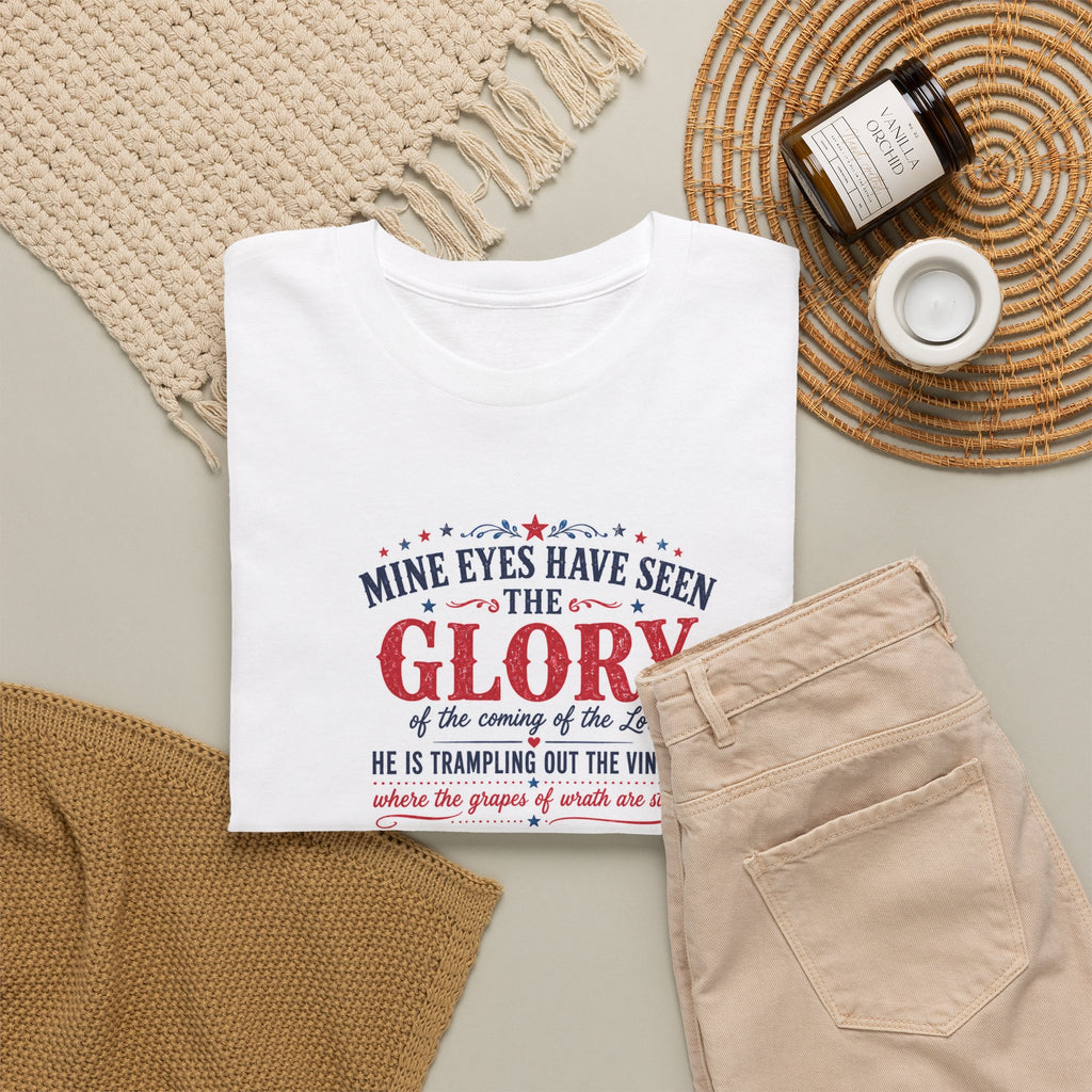 White t-shirt with religious text design on a neutral surface with jeans and a candle.
