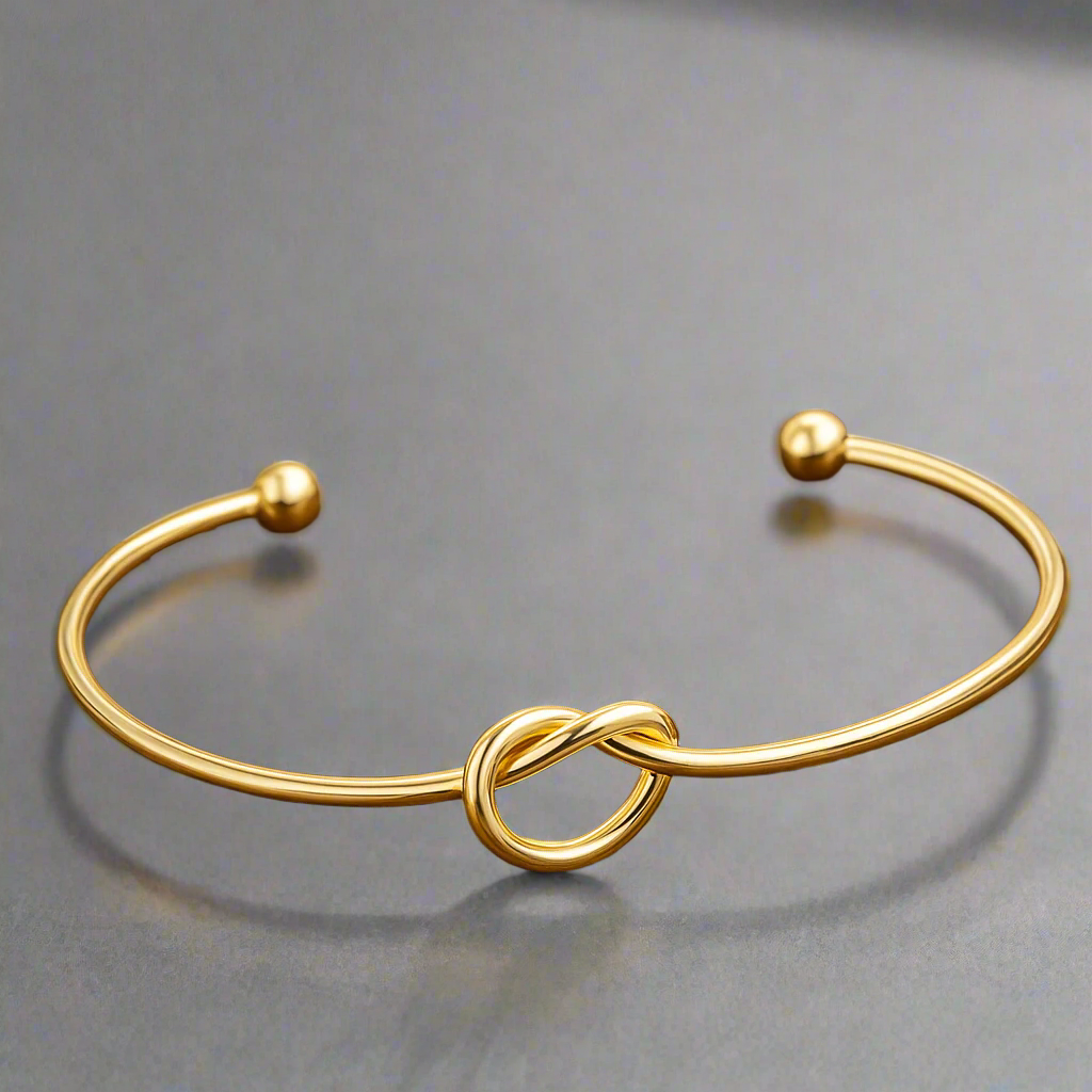 Gold bracelet with a knot design on a gray background